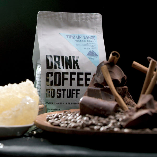 Coffee bag with a plate of coffee beans, chocolate, cinnamon sticks, and honeycomb seen in the foreground.